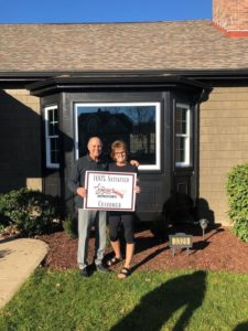 Energy Swing Windows employee posing for picture with satisfied customer in front of her newly installed energy-efficient window.