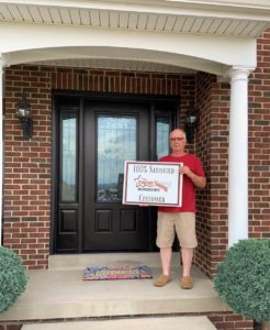 Satisfied customer standing in front of newly installed front door.
