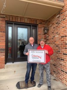 View of satisfied homeowner alongside Energy Swing Windows employee standing by newly installed front door.