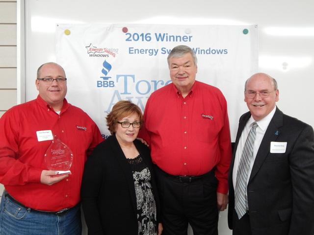 four people in red and black shirts win an award